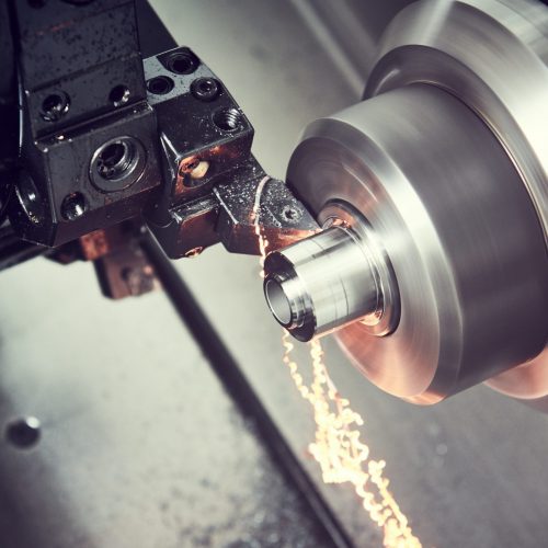 metalworking industry. cutting tool processing steel metal detail on turning lathe machine in workshop